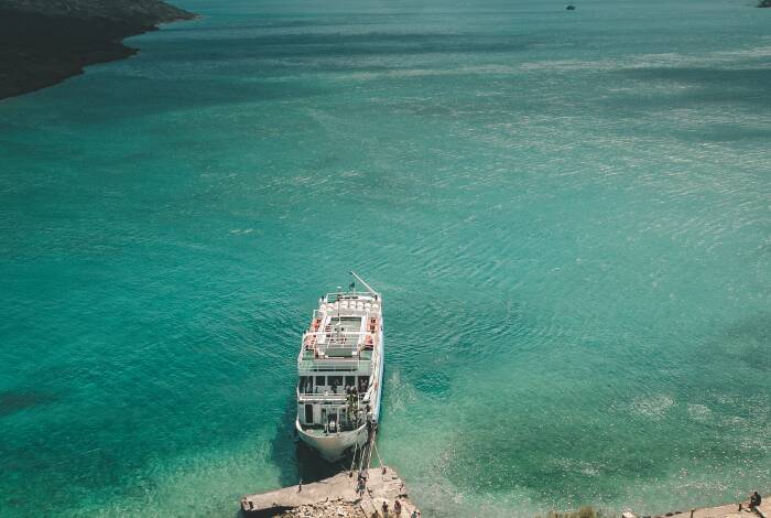 Boot am Steg von Agios Nikolaos | Unsplash: Egor Myznik