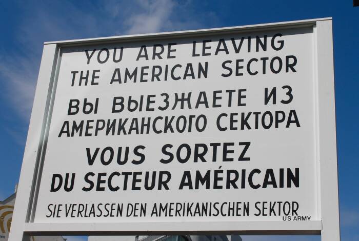 Wachschild beim Checkpoint Charlie | Photo: Unsplash, Marie Rouilly