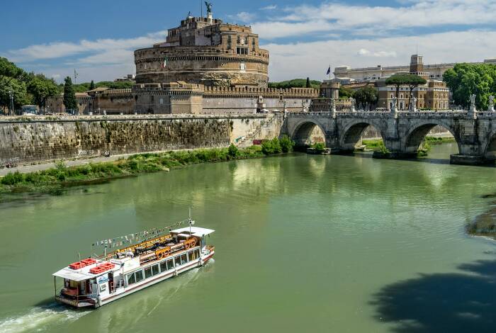 Boat travels along the Tiber past the Castel Sant'Angelo | Photo: Unsplash, Kent Rebman
